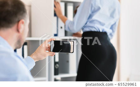 Man Taking Picture Of His Female Coworker's Ass In Office Man Taking Picture Of His Female Coworker's Ass In Office 65529961