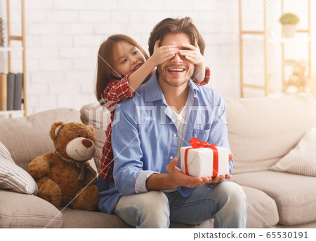 Cute preschool girl covering her dad eyes on Father Day Cute preschool girl covering her dad eyes on Father Day 65530191