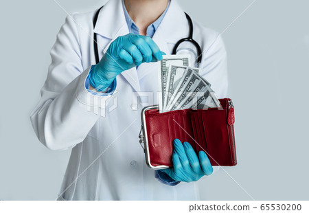Doctor in white coat holds red purse with dollars in hands and takes money Doctor in white coat holds red purse with dollars in hands and takes money 65530200