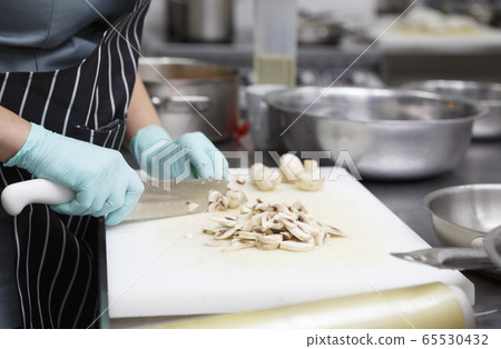 Process of slicing fresh mushrooms on cutting board Process of slicing fresh mushrooms on cutting board 65530432