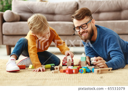 Happy dad and kid playing with toys at home. Happy dad and kid playing with toys at home. 65531079