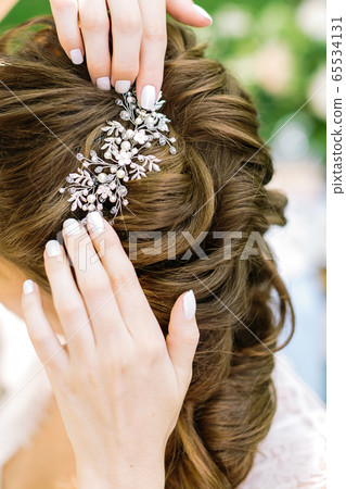 Close-up. Crop of bride's hands are correcting Close-up. Crop of bride's hands are correcting 65534131