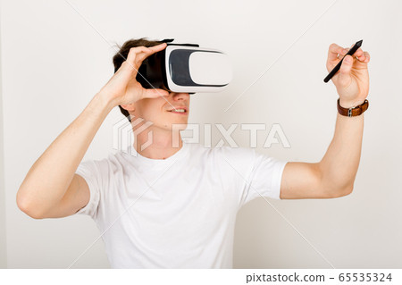 Male using virtual reality headset interacts Male using virtual reality headset interacts 65535324