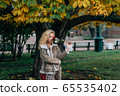 Young blond girl with closed eyes staying near 65535402