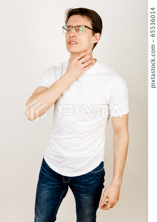 Man holds his throat with his eyes closed. Man holds his throat with his eyes closed. 65536014