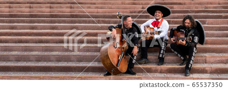 Mexican musicians play musical instruments in the city. City street in the summer. 65537350