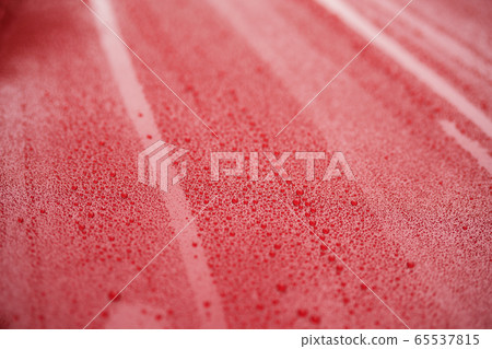 Closeup red car paint surface with hydrophobic ceramic coating 65537815