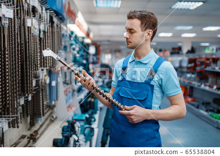 Employee choosing concrete drill in tool store Employee choosing concrete drill in tool store 65538804