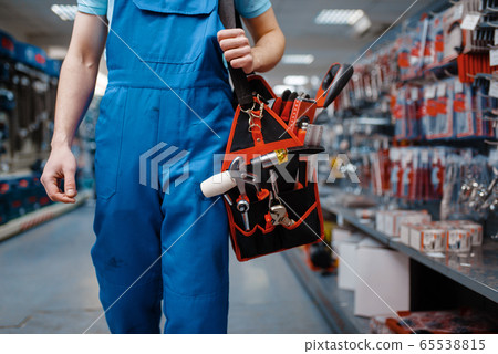 Male worker in uniform holds toolbox in tool store Male worker in uniform holds toolbox in tool store 65538815