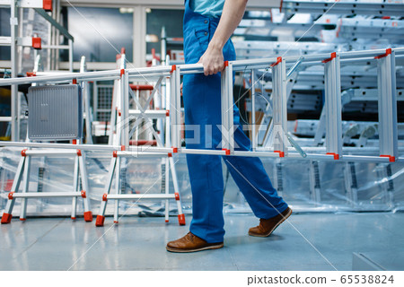 Employee holds aluminum stepladders in tool store 65538824