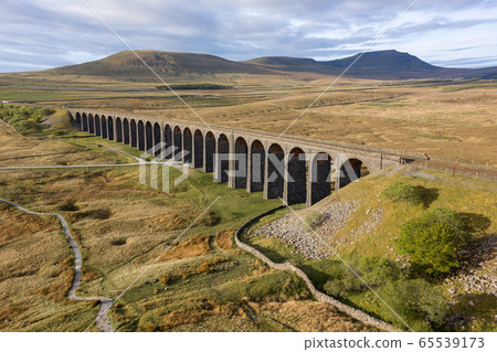 A drone shot of The Ribblehead Viaduct a Grade II listed structure, the Viaduct runs the Settle to Carlisle railway route in North Yorkshire, England. 65539173