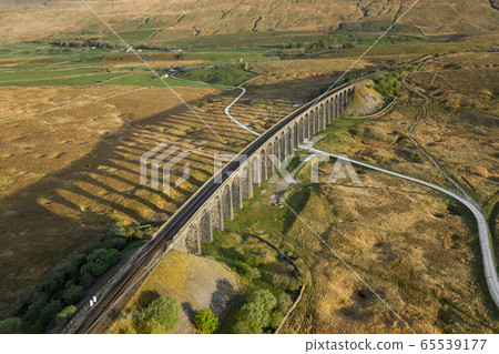 A drone shot of The Ribblehead Viaduct a Grade II listed structure, the Viaduct runs the Settle to Carlisle railway route in North Yorkshire, England. 65539177