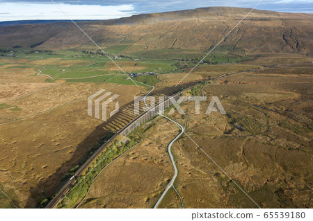 A drone shot of The Ribblehead Viaduct a Grade II listed structure, the Viaduct runs the Settle to Carlisle railway route in North Yorkshire, England. 65539180