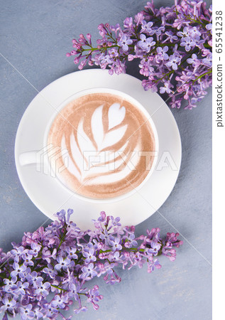 Lilac, coffee with latte art on gray wooden table. 65541238