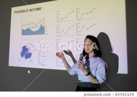 Young confident female marketer showing graph of financial development 65542329