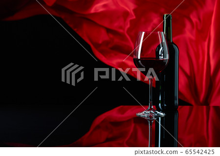 Wineglass and bottle of red wine on a black Wineglass and bottle of red wine on a black 65542425