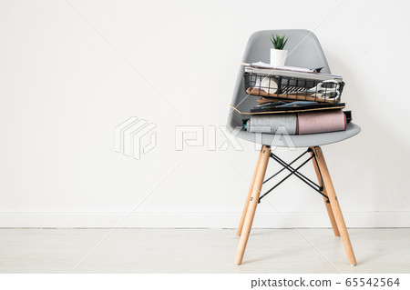 Grey plastic office chair with folded textile samples and basket with supplies Grey plastic office chair with folded textile samples and basket with supplies 65542564