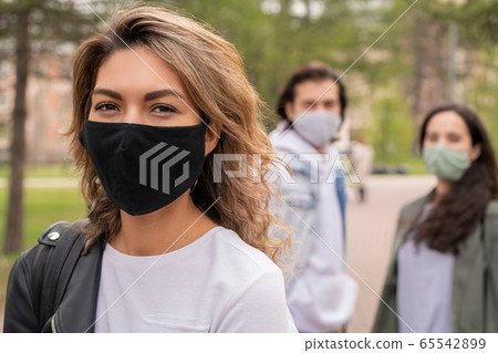 Young woman in white t-shirt, leather jacket and protective black textile mask 65542899