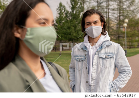 Handsome young man in protective mask and casualwear looking at you 65542917