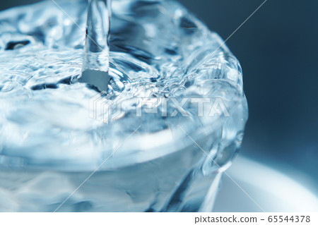 Water overflowing from the glass Water overflowing from the glass 65544378