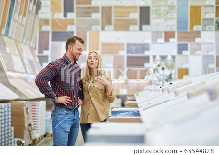 married couple are shopping together, looking for discounted things in market 65544828