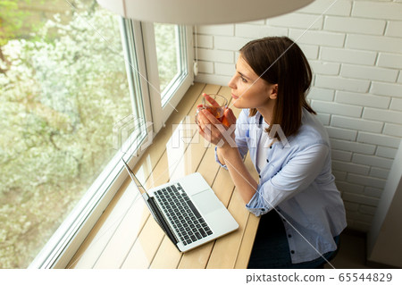 Young pretty female is looking at window Young pretty female is looking at window 65544829