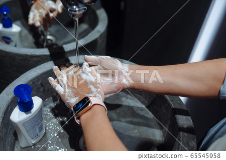 Woman washing hands to protect against the coronavirus Woman washing hands to protect against the coronavirus 65545958