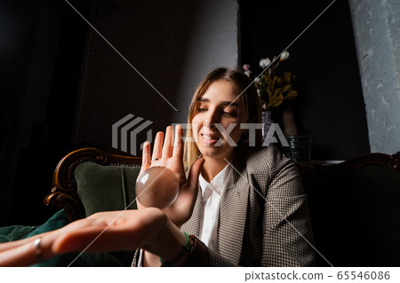 Woman in business suit holding crystal ball 65546086