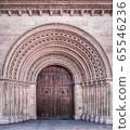 Facade with door in an arched opening, which is decorated with patterns and ornaments 65546236