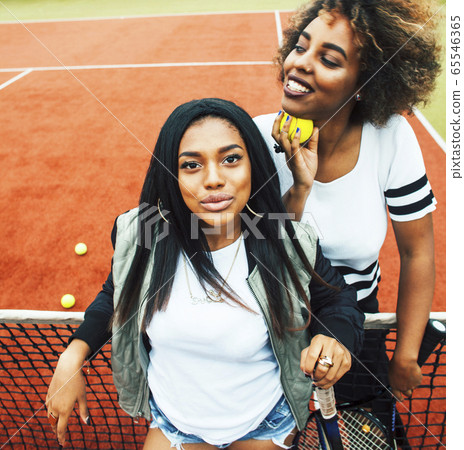 young pretty girlfriends hanging on tennis court, fashion stylish dressed swag, best friends happy smiling together 65546365