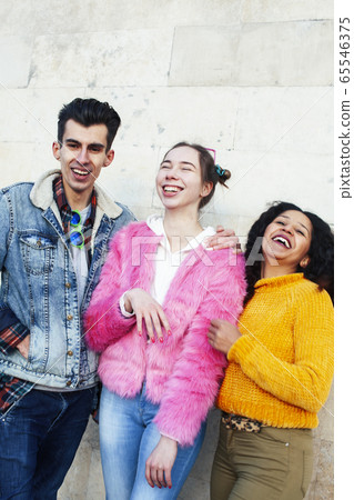 cute group of teenages at the building of university with books huggings, diversity nations real students lifestyle 65546375