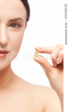 Girl holding a pill. Vitamins concept. Beautiful portrait 65546376