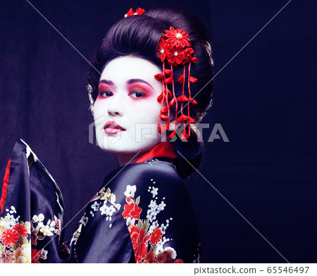 young pretty real geisha in kimono with sakura and decoration on black background 65546497