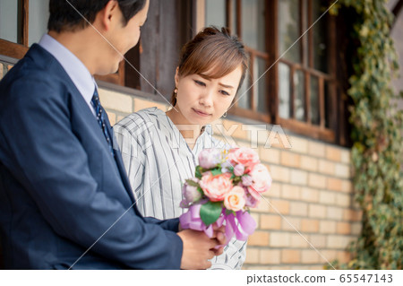 Asian woman having trouble getting a bouquet from a man 65547143