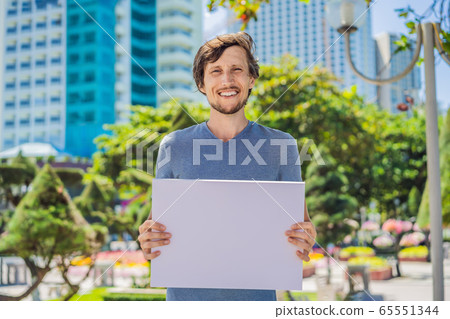 man holds a poster free for inscriptions in the city 65551344
