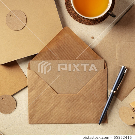 An assortment of brown kraft papers, with an envelope, a greeting card, a notebook, a label, overhead square shot 65552416