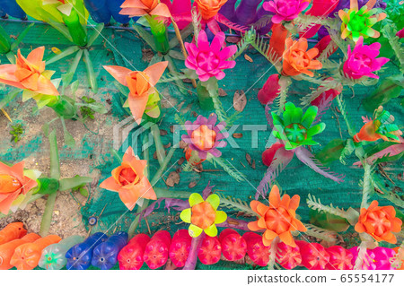 Recycled colorful plastic flowers made from plastic bottles to decorate as flowers in the garden. Plastic bottle recycled. Recycled colorful plastic flowers made from plastic bottles to decorate as flowers in the garden. Plastic bottle recycled. 65554177