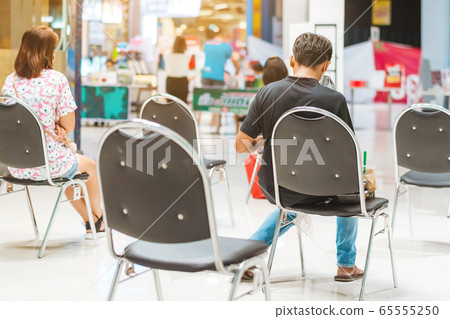 Back view of people order food and wait to take home inside of department store closed due to the coronavirus (Covid-19), Restaurants set chairs for social distancing to waiting for the food. Back view of people order food and wait to take home inside of department store closed due to the coronavirus (Covid-19), Restaurants set chairs for social distancing to waiting for the food. 65555250