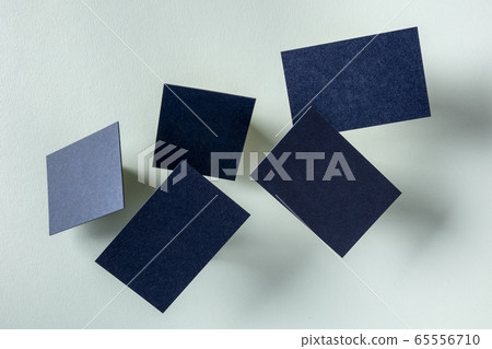 Thick blue business cards, flying on a light blue paper background, a mock-up for a creative design presentation 65556710