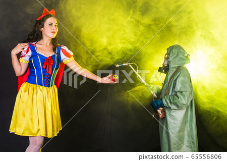 Woman dressed as fairytale character holds Radioactive atomic nuclear ionizing radiation danger warning symbol on apple. Nuclear and radiation measurement concept. Woman dressed as fairytale character holds Radioactive atomic nuclear ionizing radiation danger warning symbol on apple. Nuclear and radiation measurement concept. 65556806