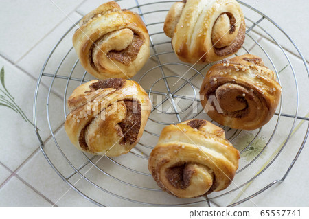 Making bread at home Cinnamon rolls Freshly baked cinnamon rolls are lined up on a net Making bread at home Cinnamon rolls Freshly baked cinnamon rolls are lined up on a net 65557741