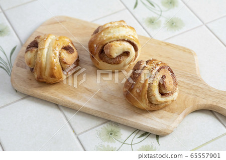 自製麵包肉桂卷新鮮的肉桂卷放在切菜板上 65557901