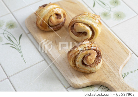 自製麵包肉桂卷新鮮的肉桂卷放在切菜板上 65557902