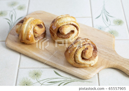 Bread making at home Cinnamon rolls Freshly baked cinnamon rolls arranged on a cutting board 65557905