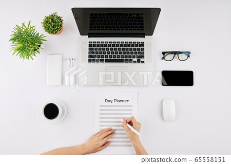 Businesswoman filling day planner 65558151