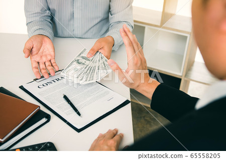 Business person refusing bribe given money by Business person refusing bribe given money by 65558205