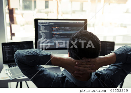 Asian programmers man are relaxing and looking at Asian programmers man are relaxing and looking at 65558239