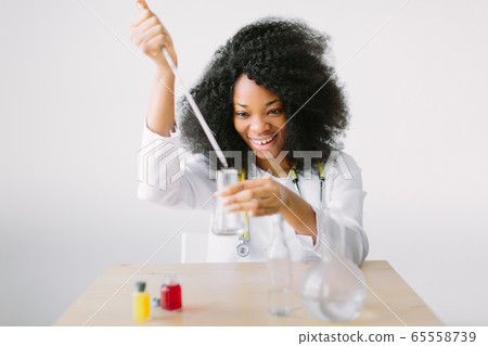 Young Female Scientist Analyzing Sample In Laboratory.laboratory assistant analyzing a sample. 65558739