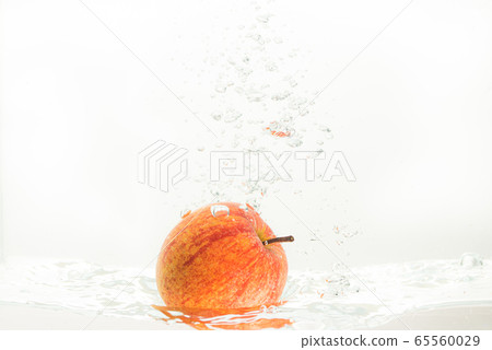 Apple falls under water with a splash. With lots 65560029