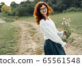 Beautiful young woman with red curly hair and freckles on her face. 65561548
